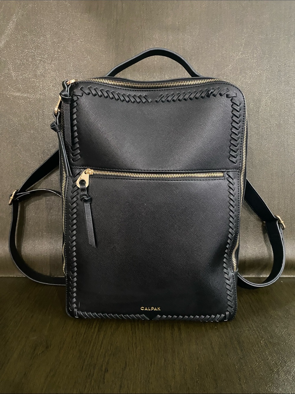 Calpak Kaya Black Faux Leather Backpack with Gold Hardware and Woven Trim